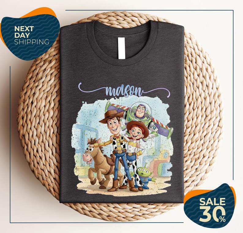 a t-shirt with a cartoon illustration of characters from the Toy Story franchise, including Woody, Buzz Lightyear, and a horse.