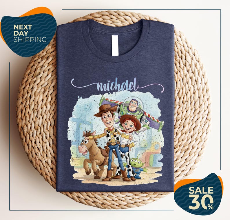 A t-shirt featuring characters from the Toy Story franchise, including Woody, Buzz Lightyear, and a girl, along with a horse and a dog.