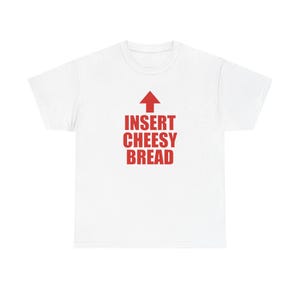 May include: White t-shirt with the text "INSERT CHEESY BREAD" in red, with a red arrow pointing upwards. The shirt is a casual, everyday wear item.