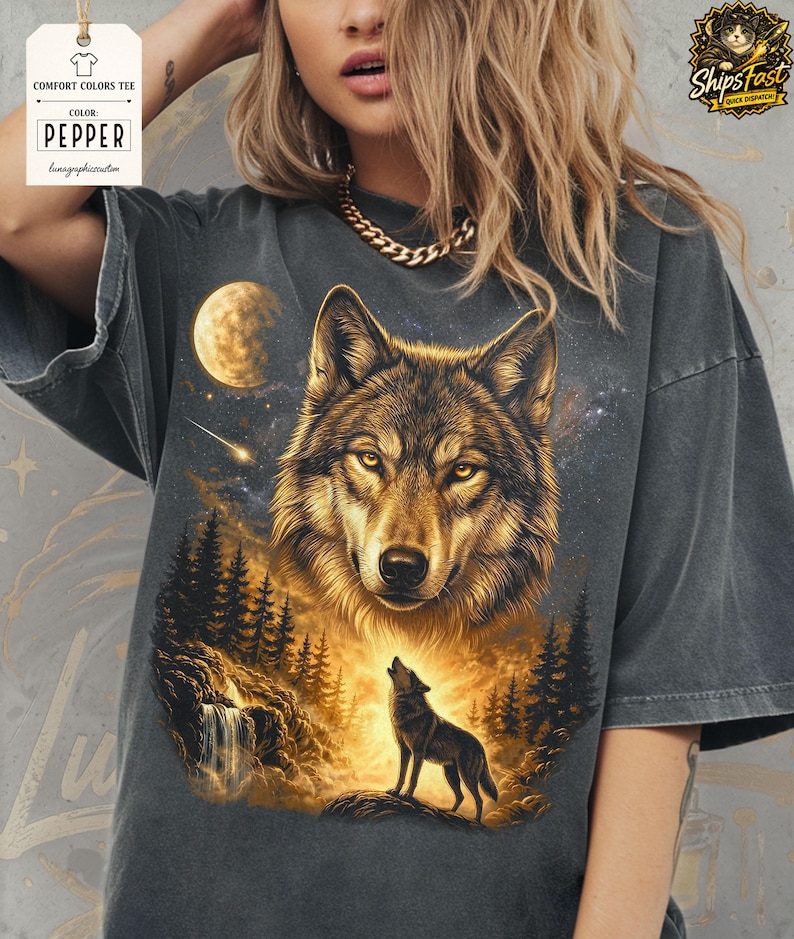 May include: Dark gray Comfort Colors tee featuring a detailed wolf design. The graphic includes a large wolf head, a howling wolf, a moon, and a starry night sky. The shirt has the text "COLOR PEPPER" on a tag.