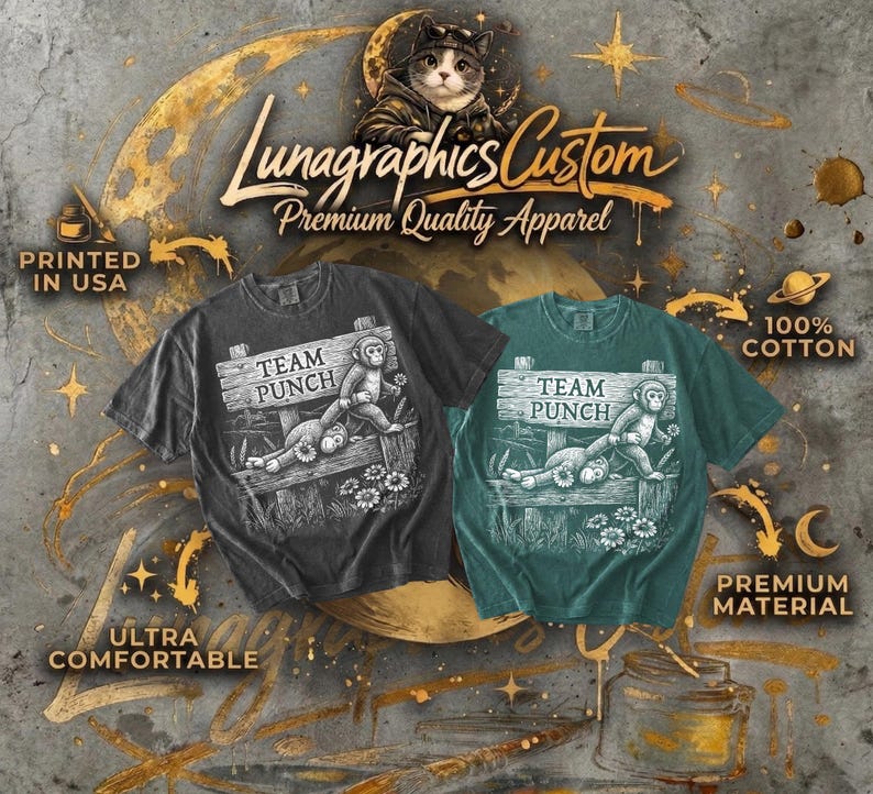 May include: Two t-shirts, one charcoal and one teal, with a graphic of a monkey on a sign saying "TEAM PUNCH". The shirts are labelled "Ultra Comfortable", "100% Cotton", and "Premium Material". The text "Lunagraphics Custom Premium Quality Apparel" is also visible.