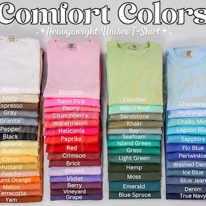 May include: A selection of Comfort Colors heavyweight unisex t-shirts in a variety of colours, including white, pink, green, and blue. The image showcases a wide spectrum of shades, from light pastels to vibrant tones, with colour names displayed below each stack.