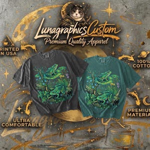 May include: Two t-shirts, one charcoal and one teal, feature a vibrant frog design. The shirts, labeled "Lunagraphics Custom," are made of 100% cotton and are described as ultra-comfortable and premium material. The text "Printed in USA" is also visible.