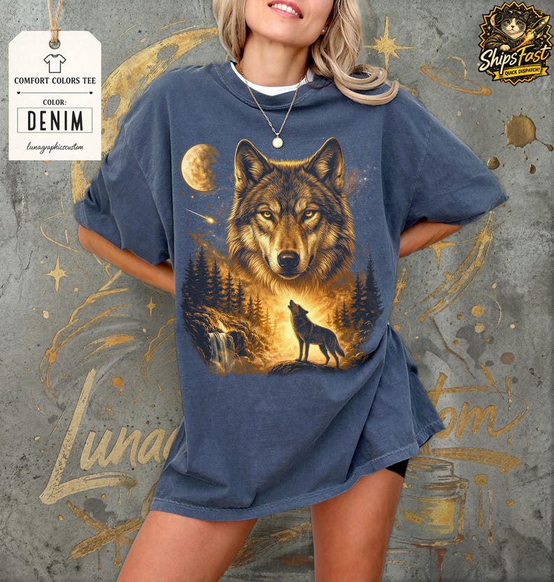 May include: Denim-colored comfort colors tee featuring a detailed illustration of a wolf howling at the moon. The design includes a forest scene with a waterfall and trees. The shirt has the text "Comfort Colors Tee" and "Denim".