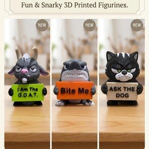 May include: Three 3D printed figurines featuring a grey goat holding a green sign reading I Am The G.O.A.T., a grey shark holding an orange sign reading Bite Me, and a black cat holding a beige sign reading ASK THE DOG, all labeled as NEW.