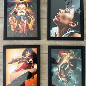 May include: Four framed art prints featuring illustrations of a woman in various poses. The artwork includes images with a fantasy theme, with a color palette of red, orange, and black. The frames are black.