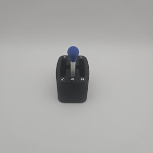 May include: A set of three ceramic mugs with a speckled, matte finish. The mugs are in shades of cream, light gray, and dark gray. Each mug has a simple, minimalist design and a rounded handle.