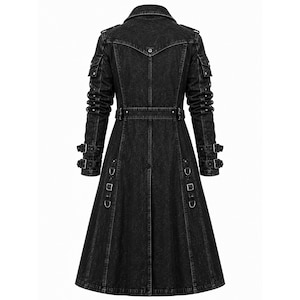 May include: A long, black denim coat featuring a structured collar, shoulder epaulets, and long sleeves with dual buckle straps at the cuffs. The coat includes a belted waist, multiple utility pockets on the upper arms, and vertical metal D-ring accents.