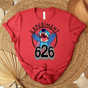 May include: Red t-shirt with a graphic of the character Stitch from Lilo & Stitch. The design includes the text "EXPERIMENT" in a circle around Stitch, with the number "626" below. The shirt is made of a soft material.