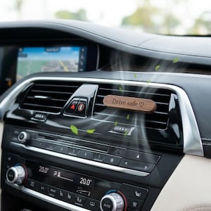 Könnte beinhalten: Eine weiße Keramik-Tasse mit schwarzem Henkel und dem Text "But First, Coffee" in schwarzer, handschriftlicher Schrift. Die Tasse steht auf einer weißen Oberfläche.