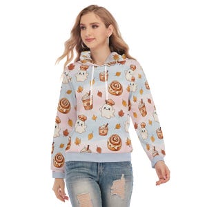 Puede incluir: Una sudadera con capucha de color azul claro con un patrón repetitivo de fantasmas de dibujos animados con gorros de chef, rollos de canela, tazas de café y hojas de otoño. Incluye un bolsillo tipo canguro y cordones blancos.