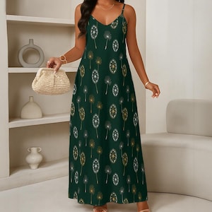 Puede incluir: Un vestido largo sin mangas de color verde oscuro con un estampado repetitivo de semillas de diente de león en blanco y dorado. La prenda tiene tirantes finos, escote en pico y una silueta recta y fluida que llega hasta el suelo.