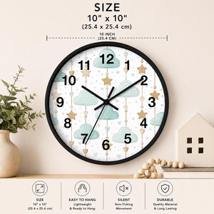 May include: A round wall clock with a black frame measuring 10 inches by 10 inches. The clock face features a white background with a pattern of light blue clouds, gold stars, and small hearts. It has black numbers and black clock hands.