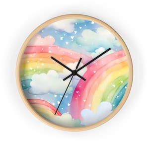 May include: A round wall clock with a light wood frame featuring a watercolor illustration of a rainbow, blue sky, and white clouds. The clock face has three black hands and is decorated with small white heart-shaped accents scattered throughout.