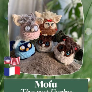 Peut inclure: Plusieurs peluches crochetées à la main, aux couleurs vives, avec des yeux proéminents et des détails de fourrure. Les couleurs incluent le rose, le bleu et le marron. Le texte "Mofu The not Furby" est affiché sur un fond vert.