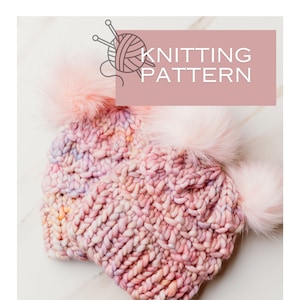 Puede incluir: Un gorro de punto rosa con dos pompones esponjosos. El gorro está hecho con hilo multicolor en tonos rosa, blanco y amarillo. El gorro está sobre una superficie de mármol blanco. El texto "Knitting Pattern" está escrito en blanco sobre un fondo rosa.