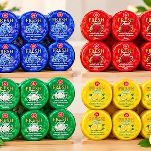 Puede incluir: Cuatro juegos de seis ambientadores circulares para inodoro Fresh Touch en aromas de lavanda azul, rosa roja, jazmín verde y limón amarillo. Cada paquete muestra el nombre del producto, el aroma e ilustraciones florales o frutales.