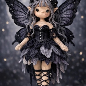 May include: A handmade crochet fairy doll with gray hair, a black dress, and large black wings. The doll has a floral crown and is wearing black boots with lace-up detailing. The fairy doll is a unique, handcrafted item.