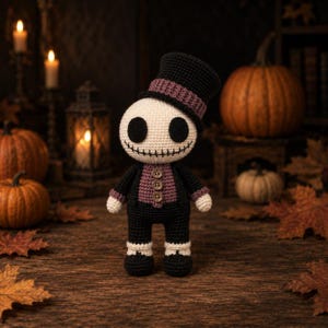May include: A crocheted Halloween doll in a top hat and suit. The doll has a cream-colored head with large black eyes and a stitched smile. It wears a black suit with a purple vest and a black top hat with a purple band. Pumpkins and autumn leaves surround the doll.