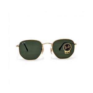 Puede incluir: Gafas de sol con montura dorada y lentes verdes. Las gafas de sol tienen forma hexagonal y un pequeño logotipo de Ray-Ban en la lente superior izquierda. Una pegatina negra y dorada está en la lente derecha, con el texto "Ray-Ban" y "G-15 LENS".