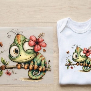 Könnte beinhalten: Aquarellillustration eines Cartoon-Chamäleons mit einer roten Hibiskusblüte, das auf einem Ast sitzt. Das Bild befindet sich auf einem transparenten Blatt und ist auch auf einem weißen Baby-Body abgedruckt. Das Chamäleon ist grün, orange und gelb.