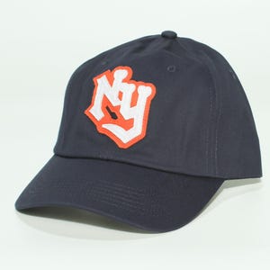 Könnte beinhalten: Marineblaue Baseballkappe mit weiß-orangefarbenem "NY"-Logo auf der Vorderseite. Die Kappe hat einen gebogenen Schirm und einen kleinen Knopf oben. Ein klassisches, lässiges Accessoire.