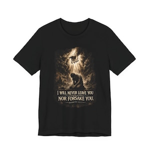Könnte beinhalten: Schwarzes T-Shirt mit einem sepiafarbenen Aufdruck, der eine kniende Person in einem Lichtstrahl zeigt, mit einer Hand, die von oben herabkommt. Der Text "I WILL NEVER LEAVE YOU NOR FORSAKE YOU" ist unter dem Bild gedruckt.
