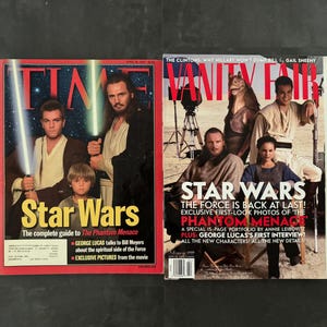 May include: Two magazines featuring Star Wars covers. The Time magazine cover has a red border and features actors with lightsabers. The Vanity Fair cover has a tan background and features actors and characters from the film.