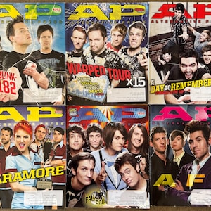 May include: A collection of six Alternative Press magazines featuring various bands. The covers display band photos and magazine titles, including "Blink-182," "Paramore," and "A Day to Remember." The magazines have a colorful design.