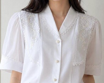 Vintage witte kanten blouse uit de jaren 70: doorschijnende pofmouw, romantische top met parelknopen