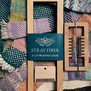 Może przedstawiać: Drewniane krosno tkackie z turkusową etykietą z napisem "STRAY FIBER 3" x 9" WEAVING LOOM". Dołączona jest igła tkacka i grzebień. Tło przedstawia kolorowe pr&oacute;bki tkanin tkanych.