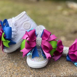 May include: A set of three ceramic mugs with a speckled, matte finish. Each mug features a different color: light blue, cream, and gray. The mugs have a simple, modern design and a comfortable handle.