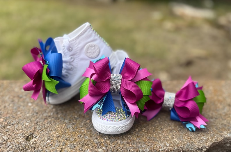 May include: A set of three ceramic mugs with a speckled, matte finish. Each mug features a different color: light blue, cream, and gray. The mugs have a simple, modern design and a comfortable handle.