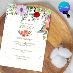 Puede incluir: Una tarjeta de invitación de cumpleaños rectangular con un borde floral de acuarela con flores moradas, rojas y naranjas y hojas verdes. El texto dice: Please join us for Stella 1st Birthday, Monday 5:00 PM, 29 December 2026, 987 Demo Blvd.
