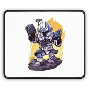 Puede incluir: Una alfombrilla de ratón de dibujos animados con una ilustración estilizada de un soldado clon con armadura blanca y azul, sosteniendo dos blasters. El fondo tiene un brillo amarillo y naranja, y la alfombrilla tiene un borde negro.