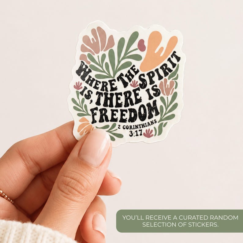 May include: A die-cut sticker featuring the black text Where The Spirit Is, There Is Freedom 2 Corinthians 3:17 surrounded by abstract floral shapes in muted tones of sage green, dusty pink, and peach on a white background.