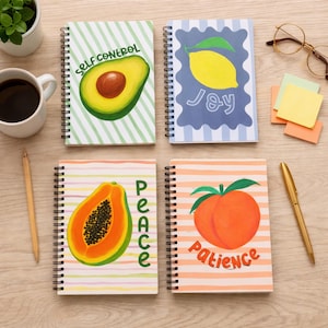 May include: A white ceramic mug with a black handle and the text "But First, Coffee" in a bold, black font. The mug is set against a blurred background, suggesting a cosy setting.