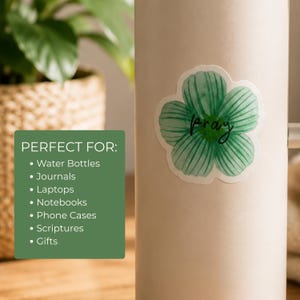May include: A sticker featuring a green watercolor-style flower with the word pray written in black cursive script across the petals. The text STICKER INFO is displayed in large black letters alongside a list of product features and uses.