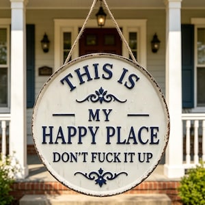 Puede incluir: Letrero redondo de metal blanco envejecido con el texto "THIS IS MY HAPPY PLACE DON'T FUCK IT UP" en azul marino. El letrero está colgado de una cuerda y es adecuado para uso en interiores o exteriores.