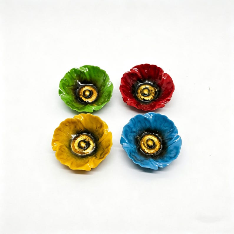 May include: Four ceramic poppy-shaped dishes in vibrant colors: green, red, yellow, and blue. Each dish features a golden center and a glossy finish, perfect for holding small items or as decorative accents.
