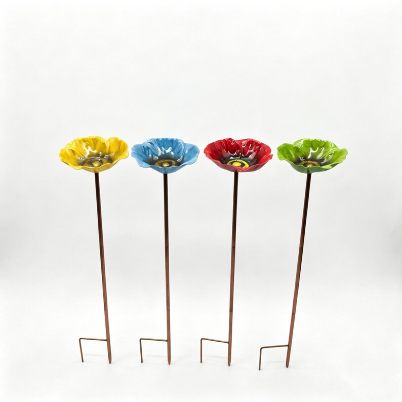 May include: Four colorful ceramic flower garden stakes. Each flower has a different color: yellow, blue, red, and green. The flower heads are mounted on brown metal stems with a metal stake at the bottom for easy placement in the garden.