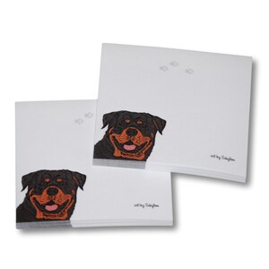 May include: A stack of white note cards with a black and brown Rottweiler dog illustration on the front. The text "art by Sibley" is printed on the bottom right corner of the card.