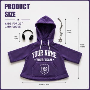 May include: A purple hooded sweatshirt for a 23-inch lawn goose, featuring white text reading YOUR NAME and YOUR TEAM above a shield graphic with TEAM LOGO. Includes black headphones and a Star of David pendant, with dimensions labeled in inches.