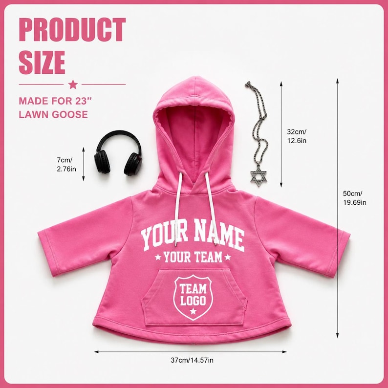 May include: A bright pink hooded sweatshirt with white drawstrings, featuring the text 'YOUR NAME', 'YOUR TEAM', and 'TEAM LOGO' in white. Includes black headphones and a silver Star of David necklace. Dimensions are 37cm/14.57in wide and 50cm/19.69in tall.