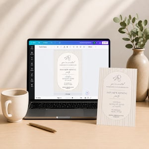 Puede incluir: Un ordenador port&aacute;til que muestra una plantilla de invitaci&oacute;n para una fiesta de inauguraci&oacute;n con fondo de rayas y marco ovalado, junto a una versi&oacute;n impresa, una taza de cer&aacute;mica y un bol&iacute;grafo dorado sobre una superficie plana.
