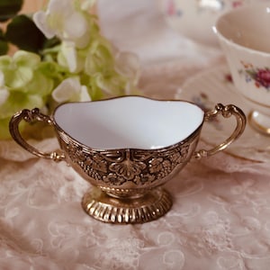 May include: A set of three ceramic mugs with a speckled, matte finish. The mugs are in shades of cream, light gray, and dark gray. Each mug has a simple, minimalist design and a rounded handle.