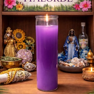 May include: A tall, purple candle in a clear glass jar is lit, with a flame at the top. The candle sits on a wooden shelf with various spiritual items, including statues, flowers, and a sign that reads "Botanica IYALORDE".
