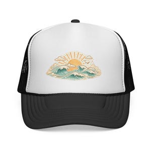 Puede incluir: Gorra de camionero en blanco y negro con un gráfico de una puesta de sol sobre olas del océano. El diseño presenta un sol amarillo, olas azules y blancas y nubes. La gorra tiene una visera negra y una parte trasera de malla.