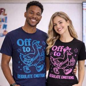 Puede incluir: Dos personas con camisetas a juego. Una camiseta es azul marino con un gráfico de pato azul y el texto "Off to Regulate Emotion". La otra camiseta es negra con un gráfico de pato rosa y el texto "Off to Regulate Emotions."