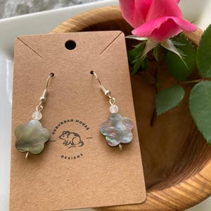 Pendientes colgantes llamativos con forma de flor de concha negra, con cuenta de piedra lunar y ganchos bañados en plata de ley.